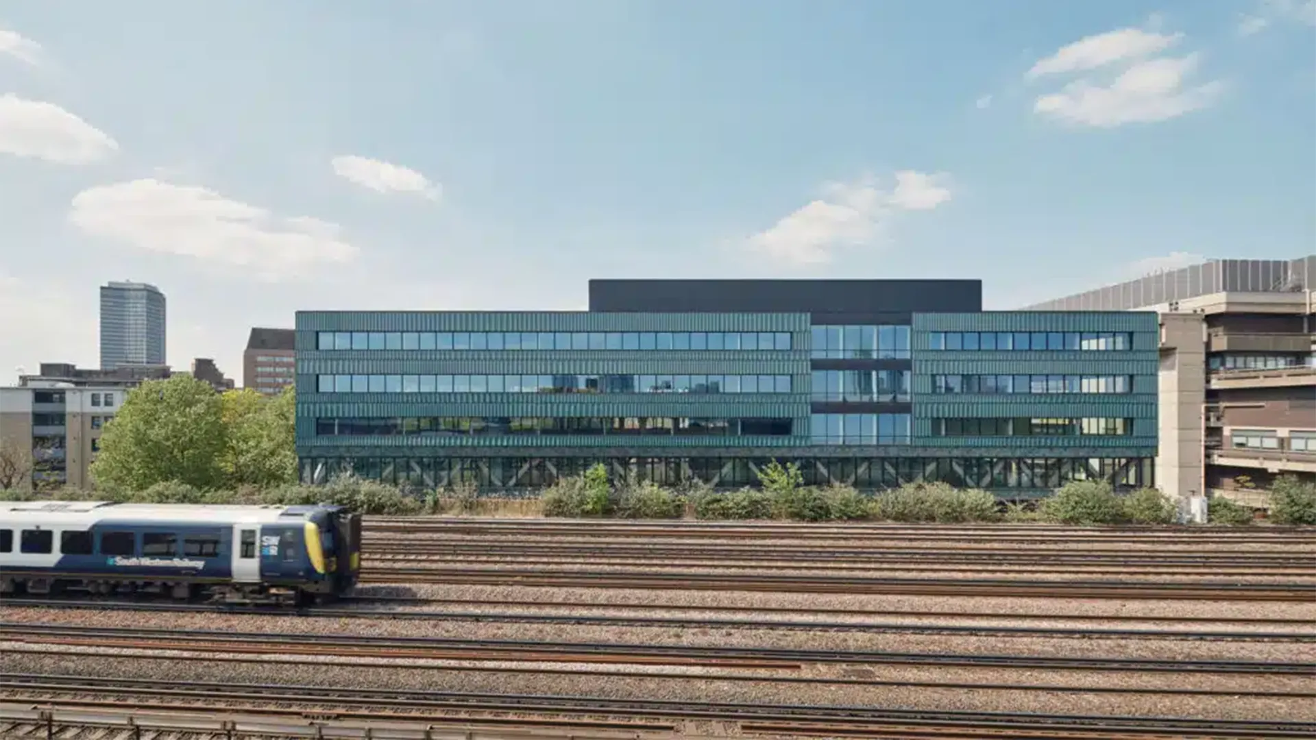 Bywater’s Paradise SE11, a 6-storey office building in Lambeth, pictured with a train passing in front of it