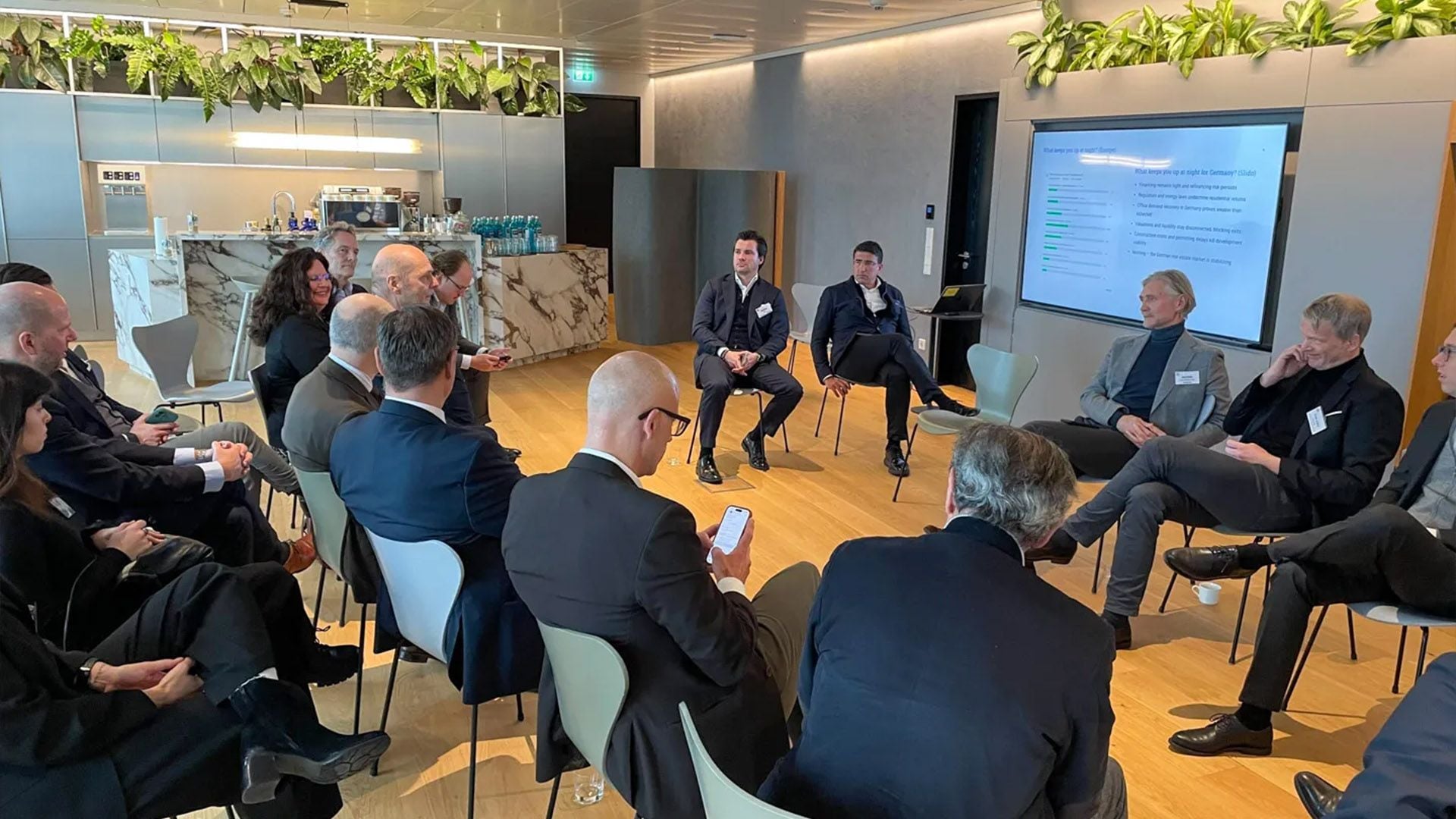 German real estate leaders discussing the results of the GRI Chairmen's Retreat survey results in Ardian's modern office space
