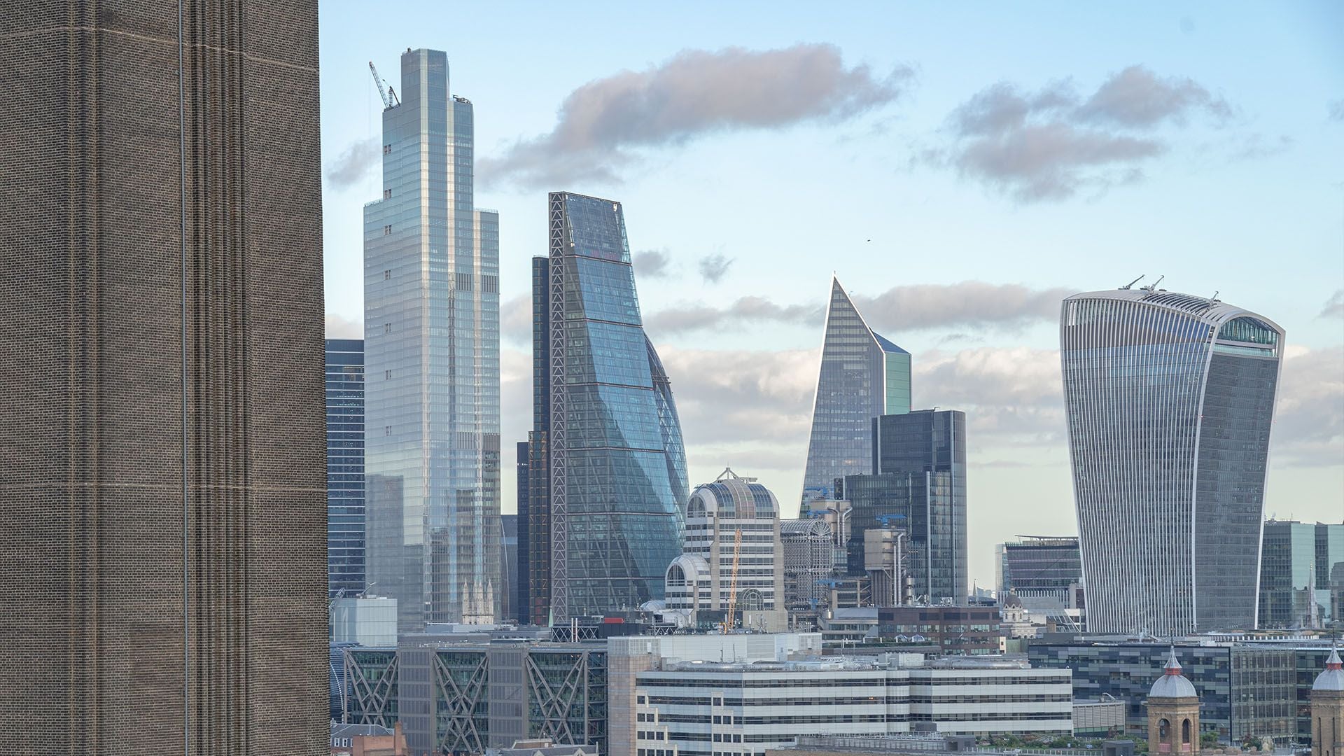A close-up view of the City of London’s iconic financial district skyline. Featured prominently are modern skyscrapers including "The Scalpel," "The Leadenhall Building" (The Cheesegrater), and "20 Fenchurch Street" (The Walkie-Talkie). The image captures a mix of glass-and-steel modernism and older masonry structures at street level.
