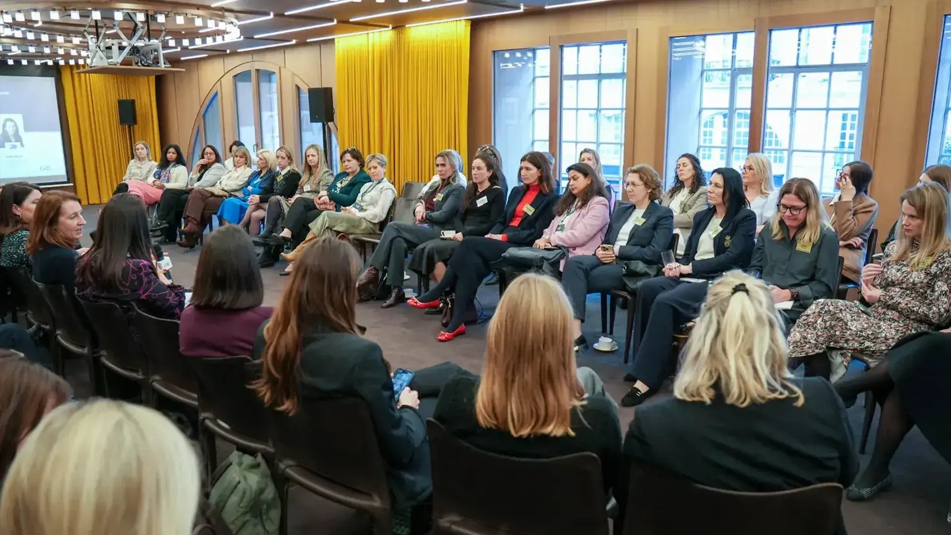 An attentive audience of female real estate professionals listening to a keynote speaker at a GRI Institute a networking event.
