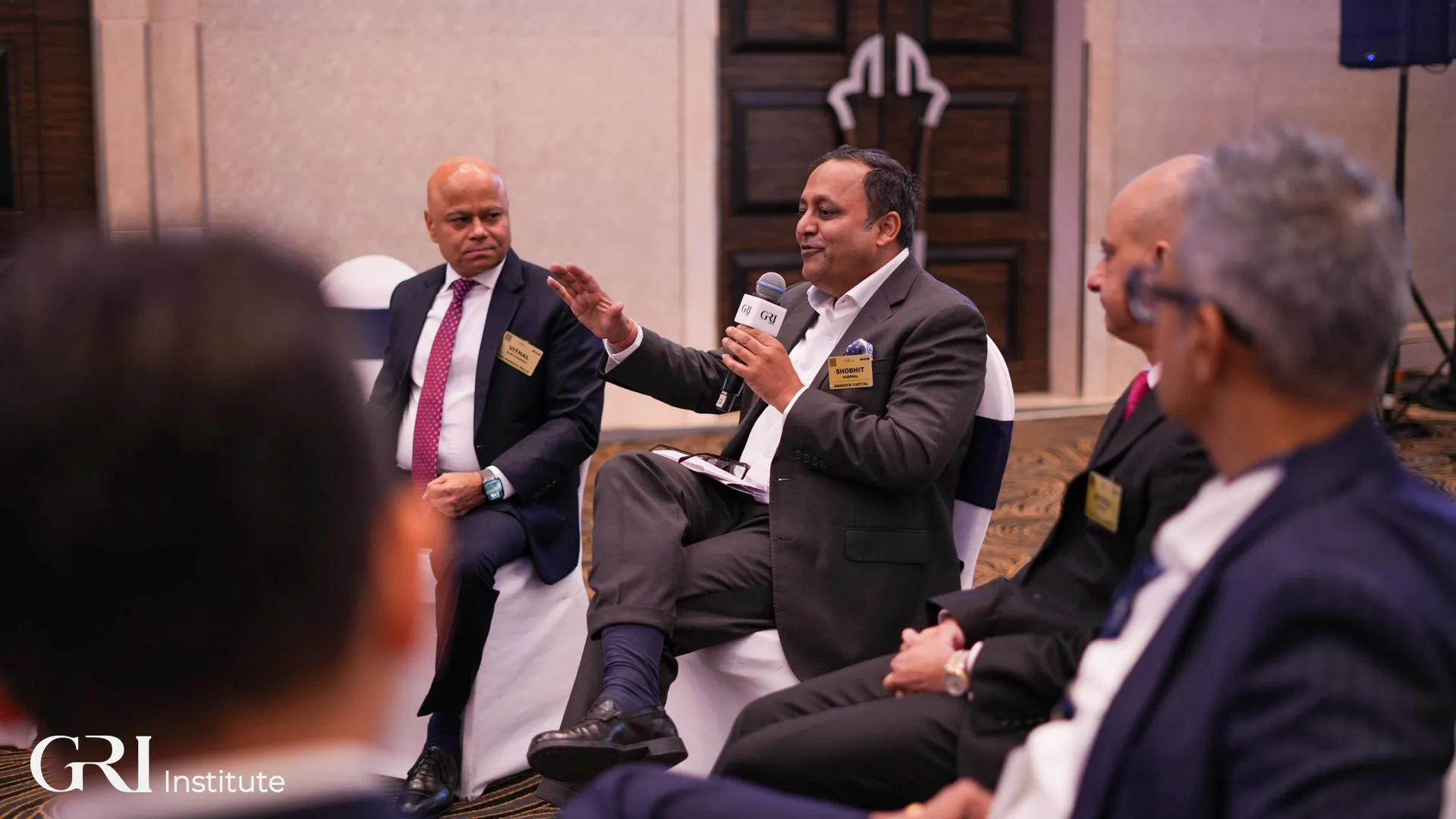 A participant speaking at the India GRI Summit, surrounded but top real estate executives.