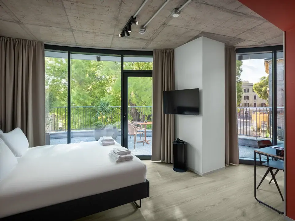 A serene, modern outdoor swimming pool, surrounded by unoccupied lounge chairs and contemporary architecture.