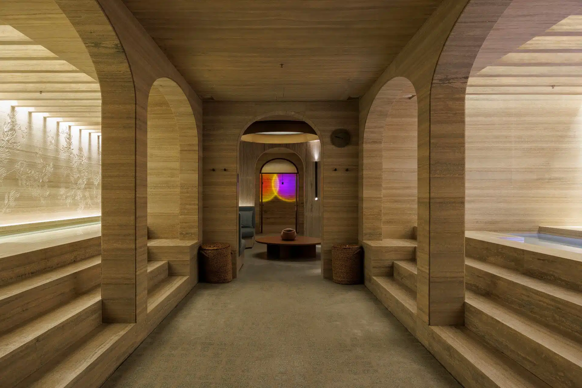 An elegant seating nook in the hotel, with velvet armchairs, a marble table, and dramatic drapery, creating an intimate and luxurious atmosphere.
