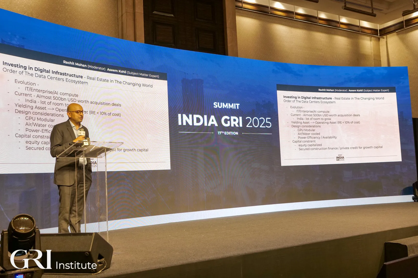 Panellist in a formal suit giving a presentation at the India GRI 2025 summit main stage.