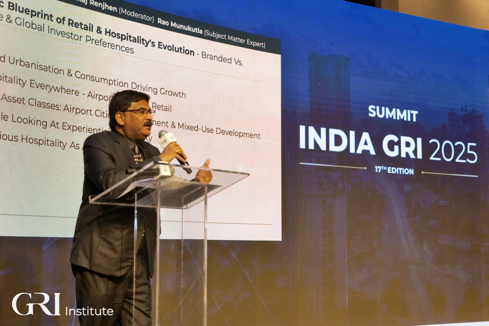 A male c-level executive giving a speech during the India GRI 2025 Summit.