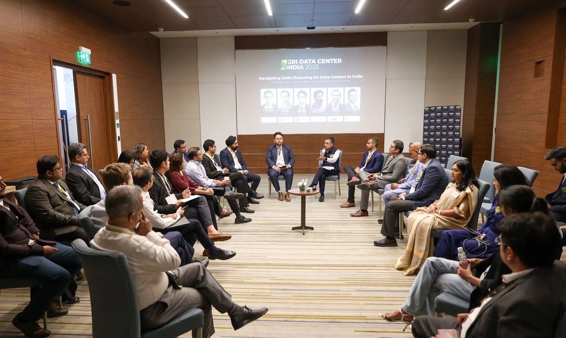 A group of formal dressed industry leaders gathered in a closed-door meeting during GRI Data Center 2025.
