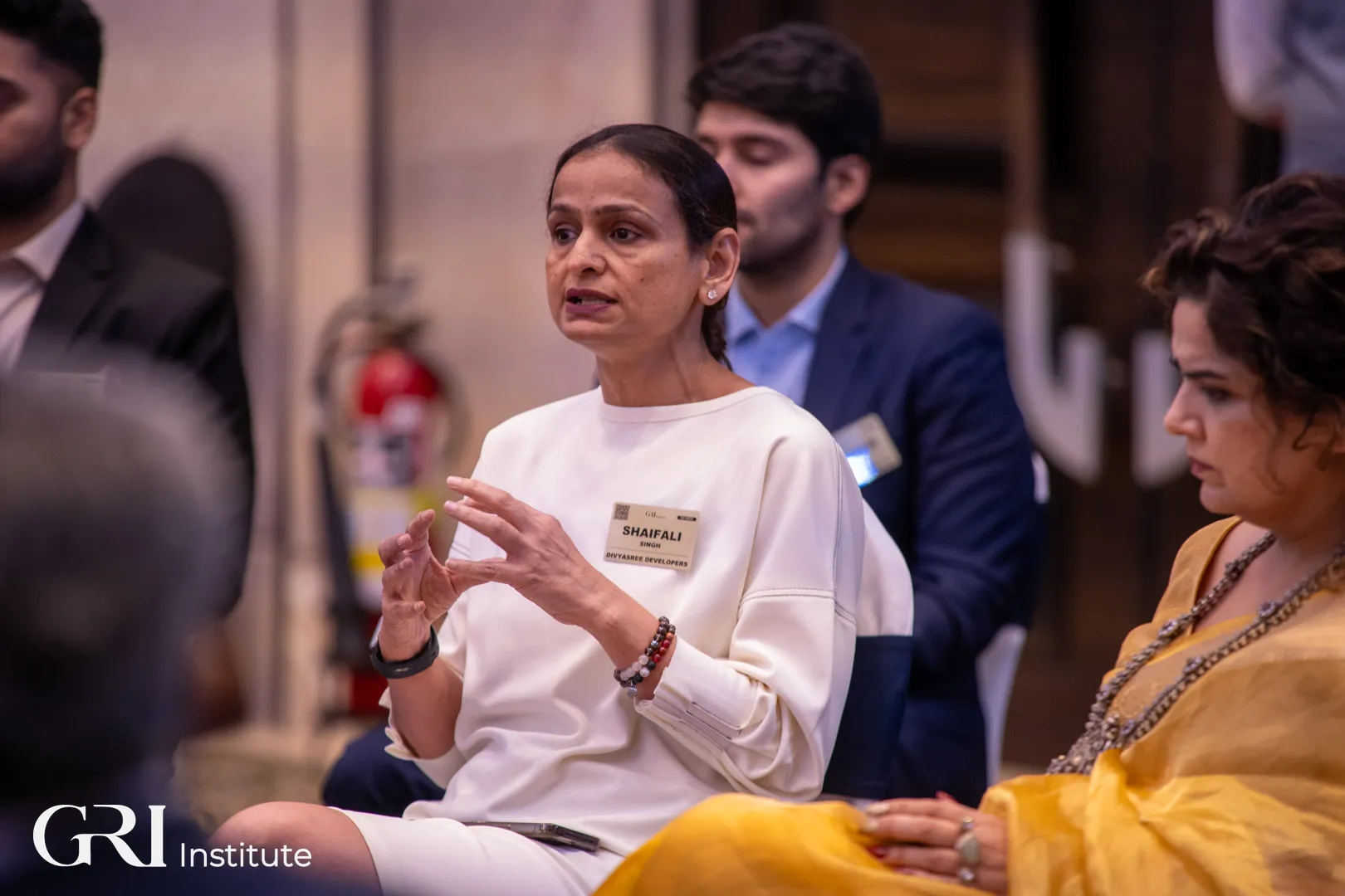 A female executive sharing insights during a panel discussion with other real estate leaders at the India GRI 2025 summit.