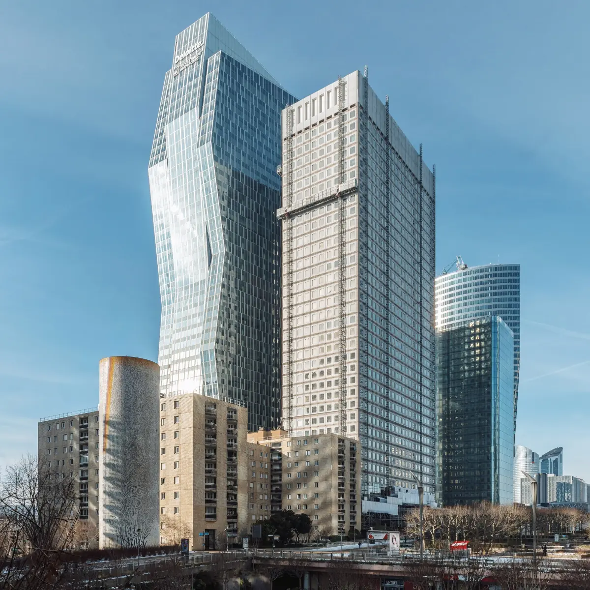 Close-up of the structural details of Tour Ariane with surrounding cityscape in La Défense