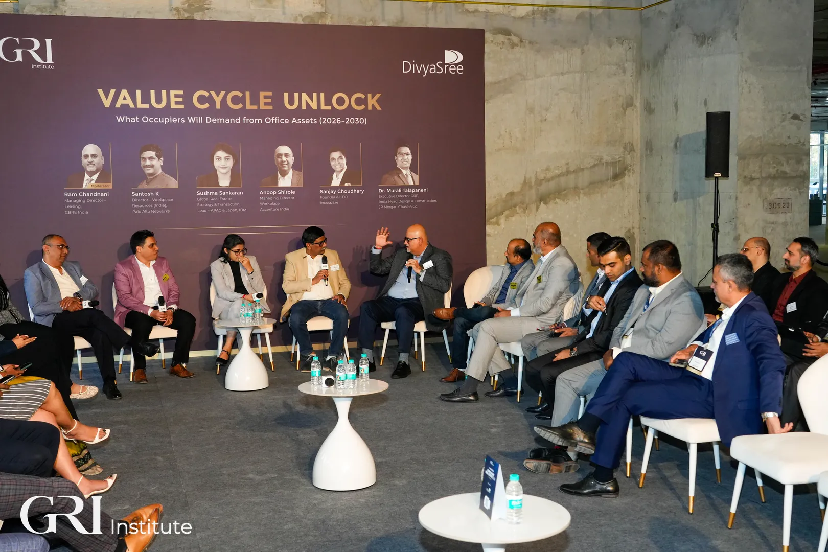 Senior industry leaders and occupiers engaged in an intimate roundtable discussion at the Bangalore RE 2026 event, set against the raw backdrop of a live construction site.
