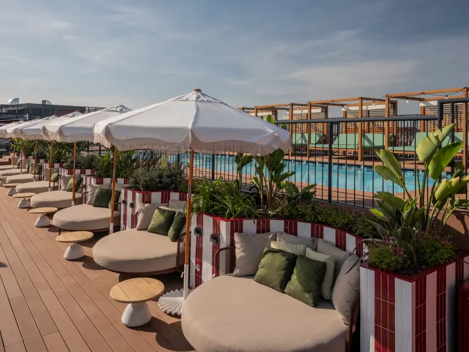 A calm, close-up view of a turquoise swimming pool's clear water and a submerged seating ledge.