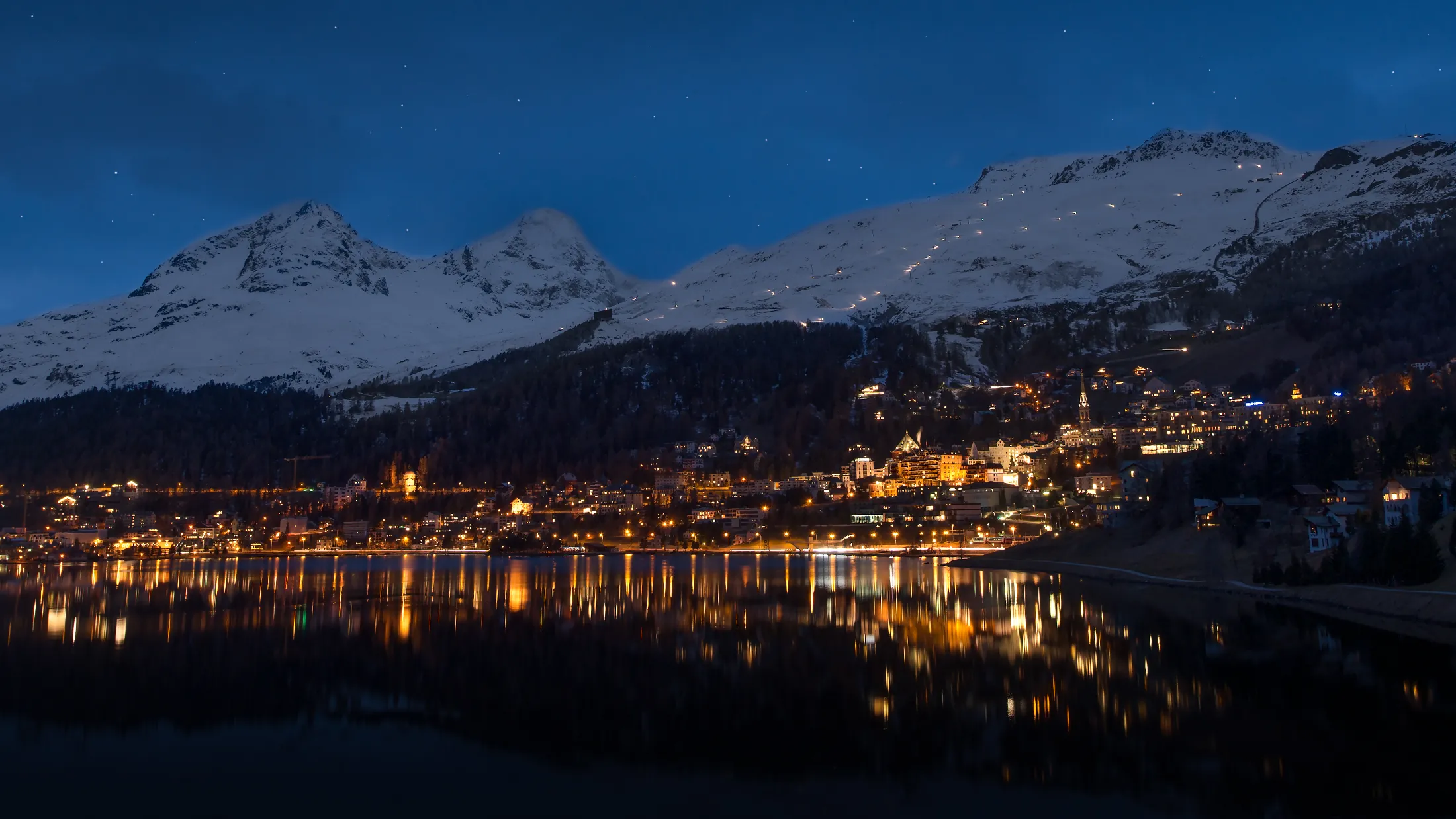 St. Moritz à noite, com lago e montanhas nevadas